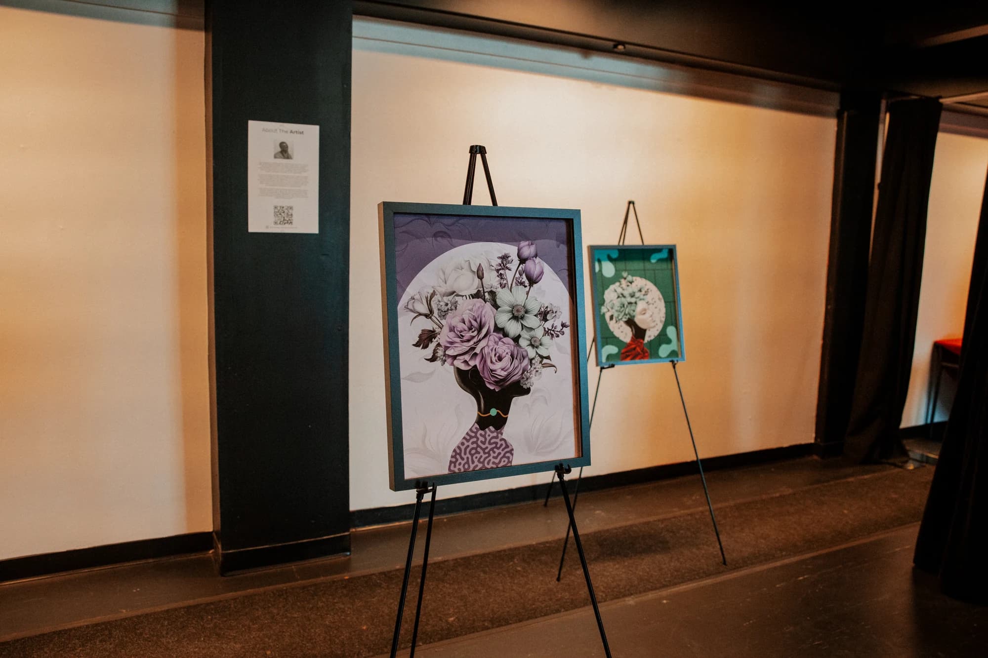 Community Champions artworks displayed on easels at the exhibition, in black and white